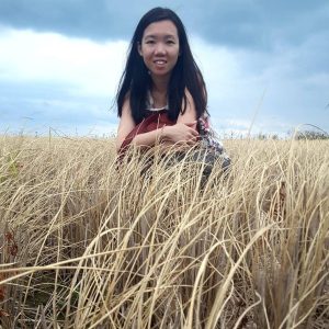 Amanda Tay in a field of grass, smiling at the camera.